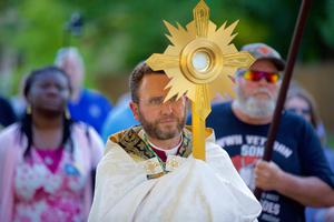 Bishop Andrew Cozzens carries the Eucharist in a monstrance during a procession June 19 at an event called Catholic Father’s Day. After Mass at Maternity of Mary in St. Paul, the 1.5-mile procession made a trip from the church to Lake Como and back. Bishop Andrew Cozzens carries the Eucharist in a monstrance during a procession June 19 at an event called Catholic Father’s Day. After Mass at Maternity of Mary in St. Paul, the 1.5-mile procession made a trip from the church to Lake Como and back.