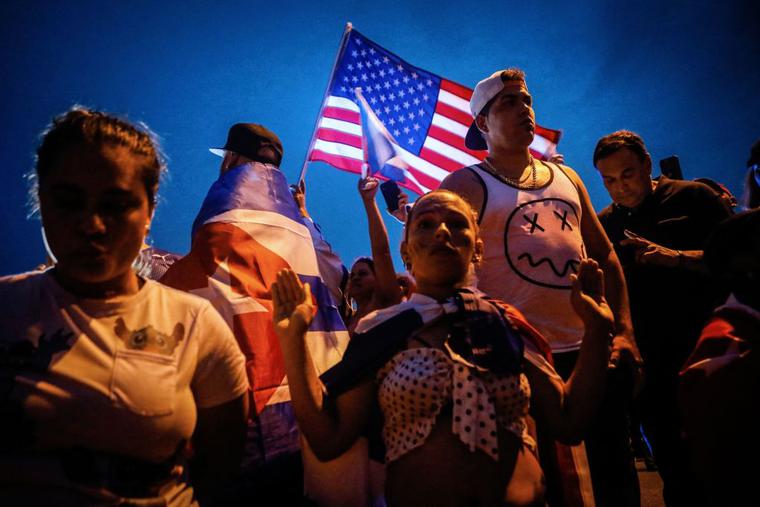 A woman kneels as people block Palmetto Expressway during a protest showing support for Cubans demonstrating against their government, in Miami, on July 13, 2021. A woman kneels as people block Palmetto Expressway during a protest showing support for Cubans demonstrating against their government, in Miami, on July 13, 2021.