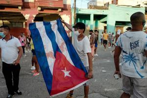 A man waves a Cuban flag during a demonstration against the government of Cuban President Miguel Diaz-Canel in Havana, on July 11, 2021 after thousands of Cubans took part in rare protests against the communist government. A man waves a Cuban flag during a demonstration against the government of Cuban President Miguel Diaz-Canel in Havana, on July 11, 2021 after thousands of Cubans took part in rare protests against the communist government.