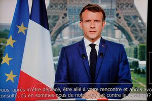 French President Emmanuel Macron is seen on a TV screen as he speaks during a televised address to the nation from the temporary Grand Palais in Paris on July 12. Macron announced that a 'COVID pass' will be needed in restaurants starting Aug. 1. French President Emmanuel Macron is seen on a TV screen as he speaks during a televised address to the nation from the temporary Grand Palais in Paris on July 12. Macron announced that a 'COVID pass' will be needed in restaurants starting Aug. 1.