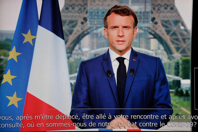 French President Emmanuel Macron is seen on a TV screen as he speaks during a televised address to the nation from the temporary Grand Palais in Paris on July 12. Macron announced that a 'COVID pass' will be needed in restaurants starting Aug. 1. French President Emmanuel Macron is seen on a TV screen as he speaks during a televised address to the nation from the temporary Grand Palais in Paris on July 12. Macron announced that a 'COVID pass' will be needed in restaurants starting Aug. 1.