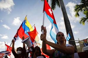 People hold Cuban, Peruvian and Venezuelan flags during a protest showing support for Cubans demonstrating against their government, at Versailles Restaurant in Miami, on July 18, 2021. People hold Cuban, Peruvian and Venezuelan flags during a protest showing support for Cubans demonstrating against their government, at Versailles Restaurant in Miami, on July 18, 2021.