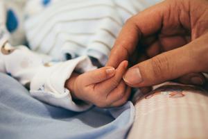 A mother holds her newborn baby's hand. A mother holds her newborn baby's hand.
