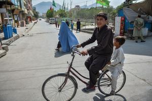 Boys ride a bicycle along a road in Kabul on August 19, 2021, amid the Taliban's military takeover of Afghanistan. Boys ride a bicycle along a road in Kabul on August 19, 2021, amid the Taliban's military takeover of Afghanistan.