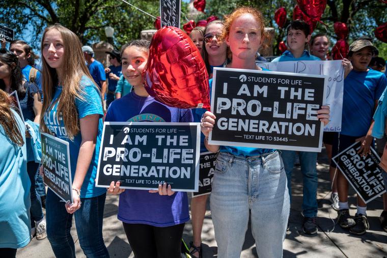 Pro-life protesters holding Students for Life signs stand near the gate of the Texas state capitol at a protest outside the Texas state capitol on May 29, 2021 in Austin, Texas. Pro-life protesters holding Students for Life signs stand near the gate of the Texas state capitol at a protest outside the Texas state capitol on May 29, 2021 in Austin, Texas.
