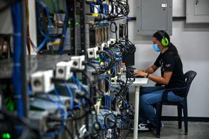 An employee inspects computers used to mine Bitcoins at the mining showroom of the Doctorminer company in Caracas on August 18, 2021. In a Venezuela with ridiculously low electricity costs, mining cryptocurrencies has become a very profitable business, albeit a target for extortion. An employee inspects computers used to mine Bitcoins at the mining showroom of the Doctorminer company in Caracas on August 18, 2021. In a Venezuela with ridiculously low electricity costs, mining cryptocurrencies has become a very profitable business, albeit a target for extortion.