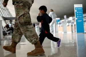An Afghan boy walks with a U.S. service member as he and his family are led through the Dulles International Airport to board a bus that will take them to a refugee processing center after being evacuated from Kabul following the Taliban takeover of Afghanistan on August 31, 2021 in Dulles, Virginia. An Afghan boy walks with a U.S. service member as he and his family are led through the Dulles International Airport to board a bus that will take them to a refugee processing center after being evacuated from Kabul following the Taliban takeover of Afghanistan on August 31, 2021 in Dulles, Virginia.