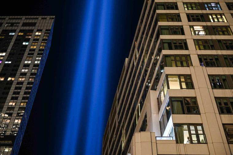 A person watches a 9/11 commemoration religious ceremony at the Greek Orthodox St. Nicholas National Shrine from the window of a building overlooking the 9/11 Memorial and Museum in New York City on Sept. 10 as the Tribute in Light shines upwards in the distance. A person watches a 9/11 commemoration religious ceremony at the Greek Orthodox St. Nicholas National Shrine from the window of a building overlooking the 9/11 Memorial and Museum in New York City on Sept. 10 as the Tribute in Light shines upwards in the distance.