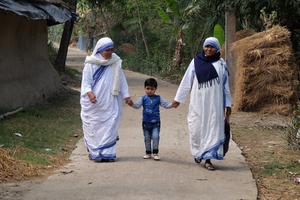 Missionaries of Charity nuns walk with a child in Chunakhali, West Bengal, India, on Feb. 26, 2020. Missionaries of Charity nuns walk with a child in Chunakhali, West Bengal, India, on Feb. 26, 2020.