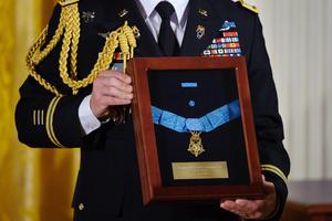 A U.S. Army officer holds the Medal of Honor for U.S. Army Chaplain (Captain) Emil J. Kapaun during an April 11, 2013, ceremony in the East Room of the White House in Washington, D.C. Father Kapuan received the medal posthumously for his service with the 3d Battalion, 8th Cavalry Regiment, 1st Cavalry Division, during combat operations against an armed enemy at Unsan, Korea. A U.S. Army officer holds the Medal of Honor for U.S. Army Chaplain (Captain) Emil J. Kapaun during an April 11, 2013, ceremony in the East Room of the White House in Washington, D.C. Father Kapuan received the medal posthumously for his service with the 3d Battalion, 8th Cavalry Regiment, 1st Cavalry Division, during combat operations against an armed enemy at Unsan, Korea.