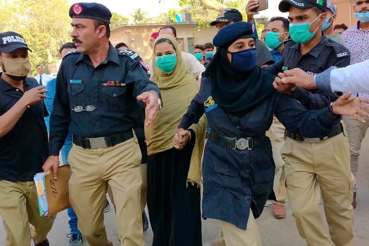 Police officers escort Arzoo Raja, center, a teenage Christian girl, who was allegedly abducted and forced to convert and marry a 44-year old Muslim, while they leave after appearance before the High Court, in Karachi, Pakistan, Nov. 3, 2020. Rights groups say each year in Pakistan, as many as 1,000 girls are forcibly converted to Islam, often after being abducted or tricked. Police officers escort Arzoo Raja, center, a teenage Christian girl, who was allegedly abducted and forced to convert and marry a 44-year old Muslim, while they leave after appearance before the High Court, in Karachi, Pakistan, Nov. 3, 2020. Rights groups say each year in Pakistan, as many as 1,000 girls are forcibly converted to Islam, often after being abducted or tricked.