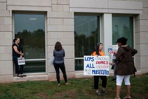 Protesters and activists hold signs as they stand outside a Loudoun County Public Schools (LCPS) board meeting in Ashburn, Virginia on October 12, 2021. Protesters and activists hold signs as they stand outside a Loudoun County Public Schools (LCPS) board meeting in Ashburn, Virginia on October 12, 2021.