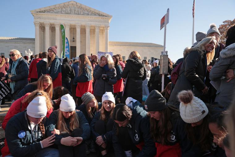 Students from Liberty University sit and pray in front of the U.S. Supreme Court as the justices hear hear arguments in Dobbs v. Jackson Women's Health, a case about a Mississippi law that bans most abortions after 15 weeks, on December 01, 2021 in Washington, DC. Students from Liberty University sit and pray in front of the U.S. Supreme Court as the justices hear hear arguments in Dobbs v. Jackson Women's Health, a case about a Mississippi law that bans most abortions after 15 weeks, on December 01, 2021 in Washington, DC.