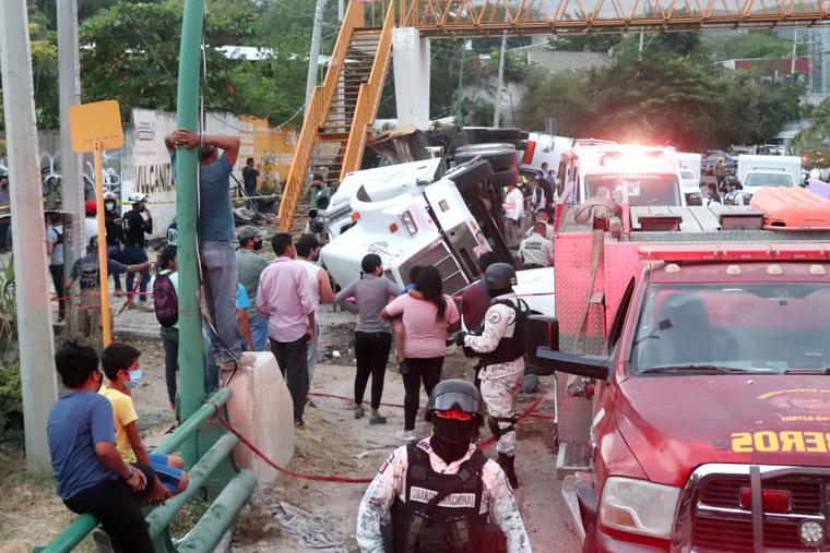Mexican national guard officers work in the area after a traffic accident that killed migrants from Central America on December 9, 2021 in Tuxtla Gutierrez, Mexico. A truck accident leaves at least 49 people dead and dozens injured according to authorities. Most of the victims are believed to be migrants from Central American who were travelling on a truck that rolled over and crashed into a pedestrian bridge. Mexican national guard officers work in the area after a traffic accident that killed migrants from Central America on December 9, 2021 in Tuxtla Gutierrez, Mexico. A truck accident leaves at least 49 people dead and dozens injured according to authorities. Most of the victims are believed to be migrants from Central American who were travelling on a truck that rolled over and crashed into a pedestrian bridge.