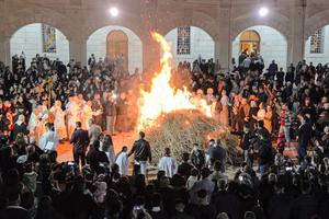 Christian worshippers gather around a bonfire outside the Syriac Catholic Church of the Immaculate Conception (Al-Tahira-l-Kubra), in Iraq's predominantly Christian town of Qaraqosh (Baghdeda), in Nineveh province, some 30 kilometres from Mosul, during the Christmas eve service on December 24, 2021. Christian worshippers gather around a bonfire outside the Syriac Catholic Church of the Immaculate Conception (Al-Tahira-l-Kubra), in Iraq's predominantly Christian town of Qaraqosh (Baghdeda), in Nineveh province, some 30 kilometres from Mosul, during the Christmas eve service on December 24, 2021.