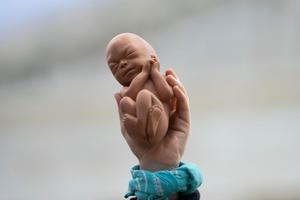 A pro-life demonstrator holds up a model of an unborn child outside the U.S. Supreme Court Building on Nov. 1, 2021, in Washington, DC. A pro-life demonstrator holds up a model of an unborn child outside the U.S. Supreme Court Building on Nov. 1, 2021, in Washington, DC.