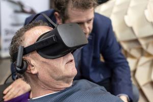 Dutch designer Alexander Bannink explains how the Sarco euthanasia machine works as a man experiences sitting in the device by wearing virtual reality glasses, on April 14, 2018, at the Amsterdam Funeral Expo. Dutch designer Alexander Bannink explains how the Sarco euthanasia machine works as a man experiences sitting in the device by wearing virtual reality glasses, on April 14, 2018, at the Amsterdam Funeral Expo.