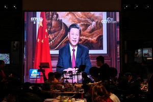 People have their dinner at a restaurant as a screen broadcasts Chinese President Xi Jinping delivering his New Year speech in Beijing on December 31, 2021. People have their dinner at a restaurant as a screen broadcasts Chinese President Xi Jinping delivering his New Year speech in Beijing on December 31, 2021.