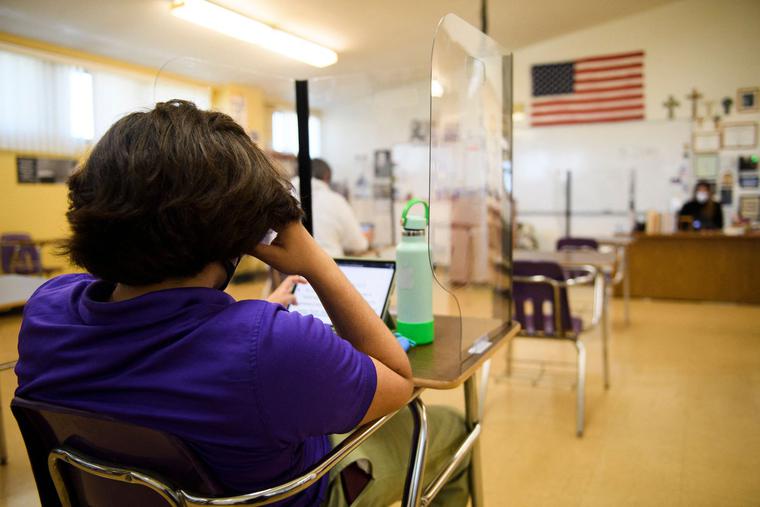 A student sits behind a barrier and works on a tablet at St. Anthony Catholic High School during the COVID-19 pandemic on March 24, 2021, in Long Beach, California. As the pandemic continues, Catholic schools are demonstrating best practices for in-person learning, complete with tried-and-true safety measures. A student sits behind a barrier and works on a tablet at St. Anthony Catholic High School during the COVID-19 pandemic on March 24, 2021, in Long Beach, California. As the pandemic continues, Catholic schools are demonstrating best practices for in-person learning, complete with tried-and-true safety measures.