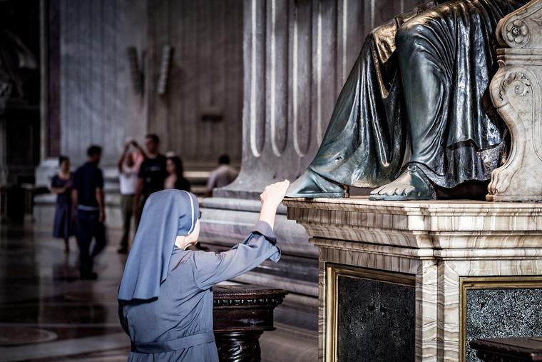 Nun at foot of Statue of St. Peter Photo Nun at foot of Statue of St. Peter Photo