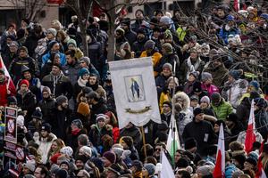Someone carries a sign with the image of the Blessed Virgin Mary at a rally of people protesting against coronavirus-related restrictions and a coming vaccination mandate on Jan. 9 in Innsbruck, Austria. Someone carries a sign with the image of the Blessed Virgin Mary at a rally of people protesting against coronavirus-related restrictions and a coming vaccination mandate on Jan. 9 in Innsbruck, Austria.