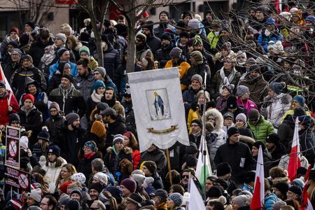 Someone carries a sign with the image of the Blessed Virgin Mary at a rally of people protesting against coronavirus-related restrictions and a coming vaccination mandate on Jan. 9 in Innsbruck, Austria. Someone carries a sign with the image of the Blessed Virgin Mary at a rally of people protesting against coronavirus-related restrictions and a coming vaccination mandate on Jan. 9 in Innsbruck, Austria.