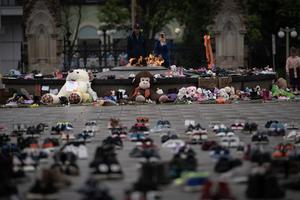 People gather round and leave shoes and toys on Parliament Hill in memory of the 215 children whose remains were found near of former Residential School in Kamloops, B.C June 2021. People gather round and leave shoes and toys on Parliament Hill in memory of the 215 children whose remains were found near of former Residential School in Kamloops, B.C June 2021.