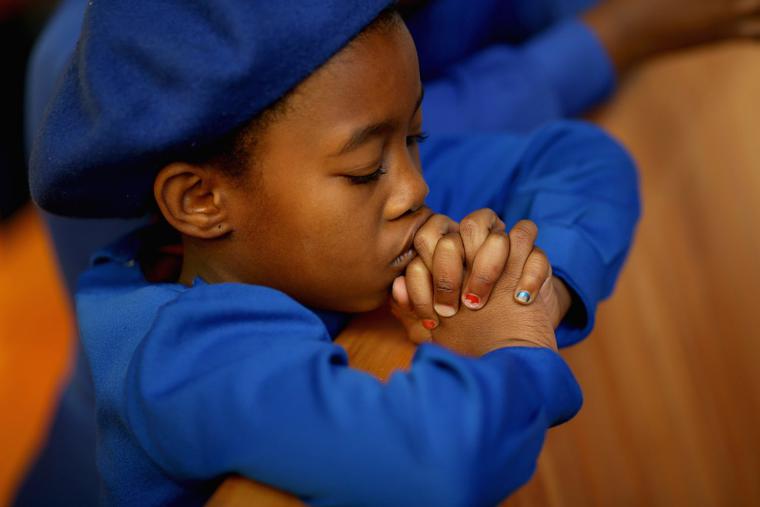 A child prays during Mass at the Regina Mundi Catholic Church in Soweto Township, June 23, 2013, in Johannesburg, South Africa. A child prays during Mass at the Regina Mundi Catholic Church in Soweto Township, June 23, 2013, in Johannesburg, South Africa.