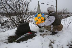 An Ukrainian servicemen lays flowers with the Ukrainian flag colors to the place where one of his friend was killed in 2017 on the frontline with the Russia-backed separatists near Avdiivka, Donetsk region, on February 2, 2022. An Ukrainian servicemen lays flowers with the Ukrainian flag colors to the place where one of his friend was killed in 2017 on the frontline with the Russia-backed separatists near Avdiivka, Donetsk region, on February 2, 2022.