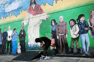A man pauses under a mural in Philadelphia’s Kensington neighborhood, which has become one of the largest open-air heroin markets in the United States, on July 19, 2021. A man pauses under a mural in Philadelphia’s Kensington neighborhood, which has become one of the largest open-air heroin markets in the United States, on July 19, 2021.