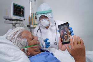 A COVID patient in the hospital uses their cellphone to communicate with their family amid pandemic restrictions. A COVID patient in the hospital uses their cellphone to communicate with their family amid pandemic restrictions.