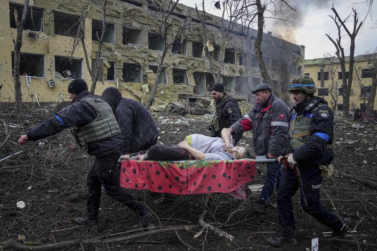 Ukrainian emergency employees and volunteers carry an injured pregnant woman from a maternity hospital that was damaged by shelling in Mariupol, Ukraine, March 9. Ukrainian emergency employees and volunteers carry an injured pregnant woman from a maternity hospital that was damaged by shelling in Mariupol, Ukraine, March 9.