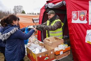 A Caritas volunteer assists Ukrainian refugees arriving at Przemyśl Główny train station in eastern Poland. A Caritas volunteer assists Ukrainian refugees arriving at Przemyśl Główny train station in eastern Poland.
