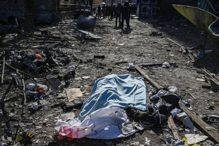 A body covered with a blanket lies among damages in a residential area after shelling in Kyiv on March 18, 2022, as Russian troops try to encircle the Ukrainian capital as part of their slow-moving offensive. -Authorities in Kyiv said one person was killed early today when a downed Russian rocket struck a residential building in the capital's northern suburbs. They said a school and playground were also hit. A body covered with a blanket lies among damages in a residential area after shelling in Kyiv on March 18, 2022, as Russian troops try to encircle the Ukrainian capital as part of their slow-moving offensive. -Authorities in Kyiv said one person was killed early today when a downed Russian rocket struck a residential building in the capital's northern suburbs. They said a school and playground were also hit.
