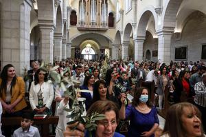 Catholic faithful attend the Palm Sunday Mass at the Church of St. Catherine in Bethlehem on April 10. Catholic faithful attend the Palm Sunday Mass at the Church of St. Catherine in Bethlehem on April 10.