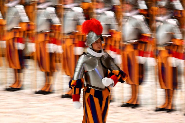 A new Swiss Guard returns to his place after his swearing-in during a ceremony for new recruits of the Pontifical Swiss Guard on Friday in the Paul VI Audience Hall at the Vatican. A new Swiss Guard returns to his place after his swearing-in during a ceremony for new recruits of the Pontifical Swiss Guard on Friday in the Paul VI Audience Hall at the Vatican.