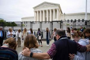 Pro-life demonstrators pray during a National Day of Prayer near an un-scalable fence that stands around the Supreme Court in Washington, DC, on May 5, 2022. Pro-life demonstrators pray during a National Day of Prayer near an un-scalable fence that stands around the Supreme Court in Washington, DC, on May 5, 2022.