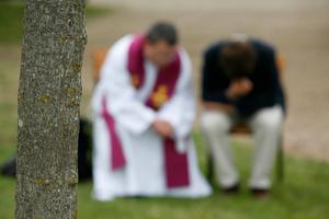 A priest hears confession in France. A priest hears confession in France.