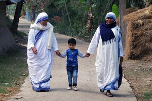 Two Missionaries of Charity walk with a child Feb. 26, 2020, in Chunakhali, West Bengal, India. Two Missionaries of Charity walk with a child Feb. 26, 2020, in Chunakhali, West Bengal, India.