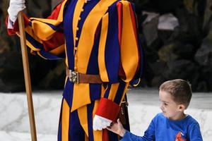 A boy who jumped from the audience takes a Swiss Guard's hand during Pope Francis’ weekly general audience on Nov. 28, 2018, in the Paul VI Audience Hall at the Vatican. A boy who jumped from the audience takes a Swiss Guard's hand during Pope Francis’ weekly general audience on Nov. 28, 2018, in the Paul VI Audience Hall at the Vatican.