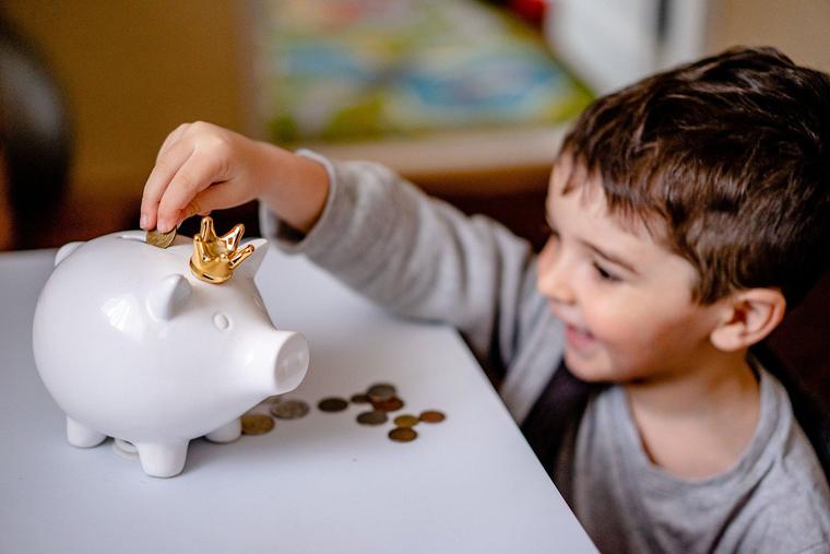 Kid with Money in the Piggy Bank Photo Kid with Money in the Piggy Bank Photo