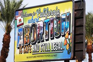 A billboard reads, ‘Welcome to California where abortion is safe and still legal’ on July 12 in Rancho Mirage, California. The billboard was paid for by Planned Parenthood of the Pacific Southwest. The number of travelers from outside states seeking abortions increased 900% at Planned Parenthood clinics in San Bernardino and Orange counties the week following the Supreme Court’s decision in the Dobbs v. Jackson Women’s Health case. A billboard reads, ‘Welcome to California where abortion is safe and still legal’ on July 12 in Rancho Mirage, California. The billboard was paid for by Planned Parenthood of the Pacific Southwest. The number of travelers from outside states seeking abortions increased 900% at Planned Parenthood clinics in San Bernardino and Orange counties the week following the Supreme Court’s decision in the Dobbs v. Jackson Women’s Health case.