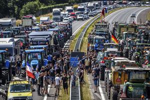 Farmers gather with their vehicles next to a Germany/Netherlands border sign during a protest on the A1 highway near Rijssen, Netherlands, June 29. They are protesting the Dutch Government's nitrogen plans, which would eliminate a sizable number of farms. Farmers gather with their vehicles next to a Germany/Netherlands border sign during a protest on the A1 highway near Rijssen, Netherlands, June 29. They are protesting the Dutch Government's nitrogen plans, which would eliminate a sizable number of farms.