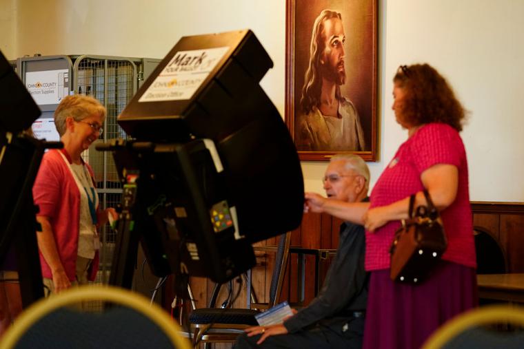 A poll worker helps a voter cast their ballot in the Kansas Primary Election at Merriam Christian Church on August 02, 2022 in Merriam, Kansas. A poll worker helps a voter cast their ballot in the Kansas Primary Election at Merriam Christian Church on August 02, 2022 in Merriam, Kansas.