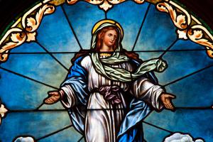 Detail of a stained-glass window depicts the Catholic doctrine of the assumption of the Blessed Virgin Mary into heaven. Detail of a stained-glass window depicts the Catholic doctrine of the assumption of the Blessed Virgin Mary into heaven.
