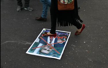 Demonstrant gazi poster sa likom Asada al Ejdanija