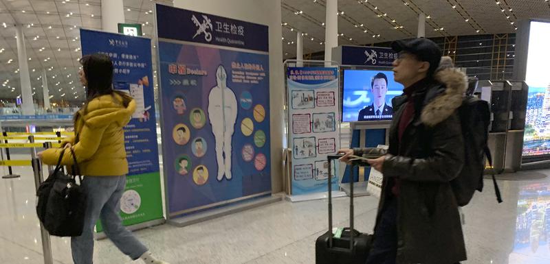 Putnici prolaze pored punkta na kojem im se provjerava zdravstveno stanje: Detalj sa aerodroma u glavnom gradu Kine, Pekingu