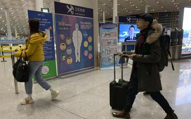 Putnici prolaze pored punkta na kojem im se provjerava zdravstveno stanje: Detalj sa aerodroma u glavnom gradu Kine, Pekingu