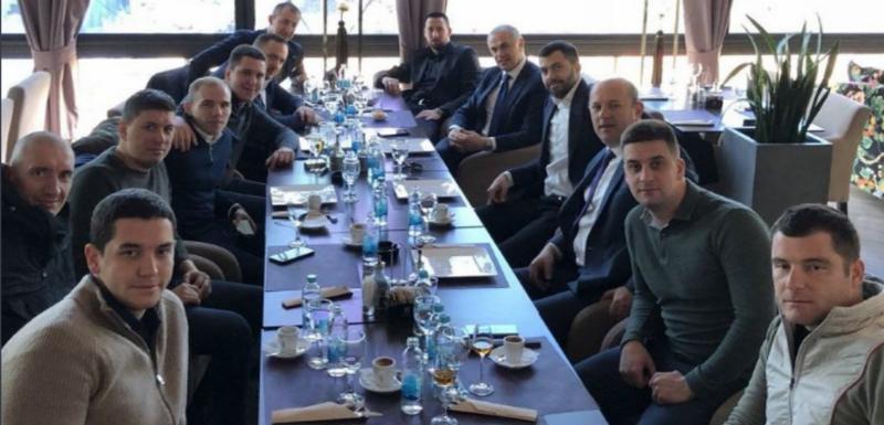 Danilo Vučić (peti slijeva), sin predsjednika Srbije Aleksandra Vučića, sjedi za stolom sa još 12 osoba među kojima su Aleksandar Vidojević zvani Aca Rošavi i Nemanja Srećković, članovi grupe"Janjičari. Za stolom su iZvezdan Terzić, generalni direktor "Crvene zvezde", Igor Dodik, sin člana predsjedništva Bosne i Hercegovine Milorada Dodika, i Vuk Radivojević, direktor u sportskom klubu "Igokea"